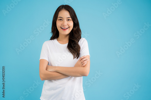 Beautiful Asian woman standing doing various poses on a blue background.