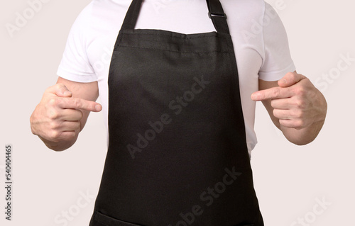 Chef cook pointing on black apron