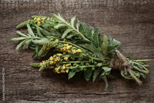 Bunch of beautiful agrimony on wooden table, top view