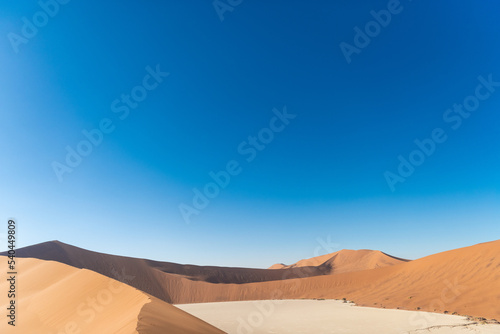 Photo of the blue sky with a duna in desert, Namibia. The concept of exotic, extreme and photo tourism.