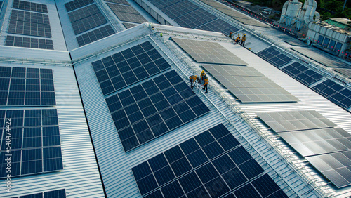 Fly over unidentified Engineering set up a Solar cell on the roof of a large industrial factory. Solar roofs are generating renewable energy for the industry.