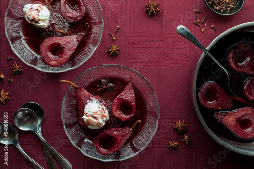 Servings of poached pears in spiced red wine sauce, ready for eating.