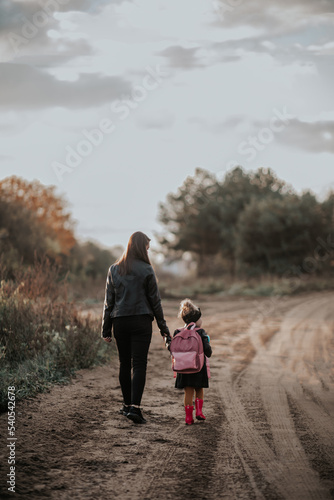 Mama odprowadza córkę z plecakiem do przedszkola