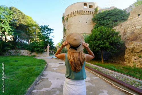 Tourism in Calabria. Back view of beautiful woman in Crotone with Charles V Aragon Castle in Crotone, Calabria, Italy.