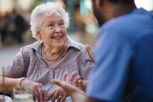 Caregiver talking with his client at cafe, having nice time together.