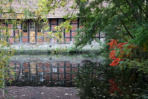 Spiegelung eines schönen alten Fachwerkhaus vom Kleinen Teich am alten Meierhof Heepen am Leithenhof an der Lutter im Herbst in Bielefeld am Hermannsweg im Teutoburger Wald in Ostwestfalen-Lippe
