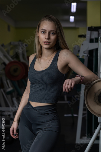 Portrait of a young beautiful blonde girl in sportswear in the gym.