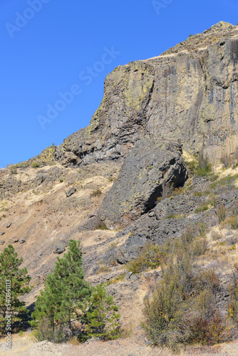 Steep basalt cliff in Central Washington in fall against clear blue sky
