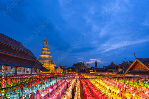 Beautiful gold pagoda and Lantern Lamp light colorful in Loi Krathong Festival hung up on the rail to pray the prosperity at Wat Phra That Hariphunchai, Lamphun, Northern Thailand.