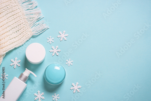 Winter cosmetic with holiday decorations on blue.