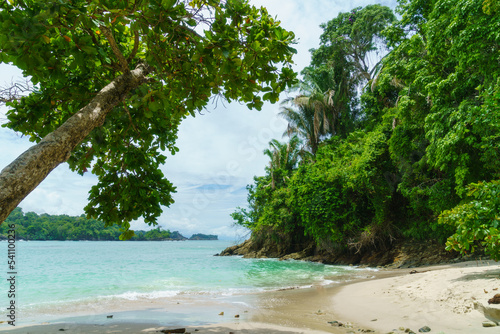 White sanded beach surrounded by tropical jungle in Costa Rica.