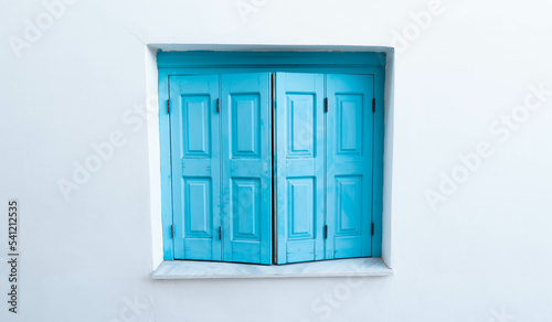 Blue window and white wall of greek house in Greece.