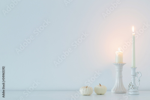 white burning candles on background white wall