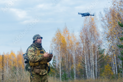 Mercenary soldier launch a reconnaissance drone in a forest.