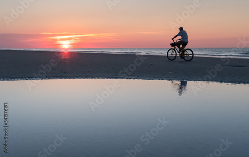 Cyclist on the beach at sunrise on Hilton Head Island, South Carolina. 