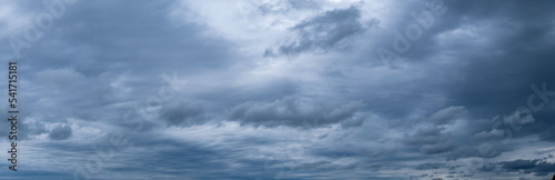 Panorama of cumulus fluffy white and dark gray storm clouds in rainy weather.