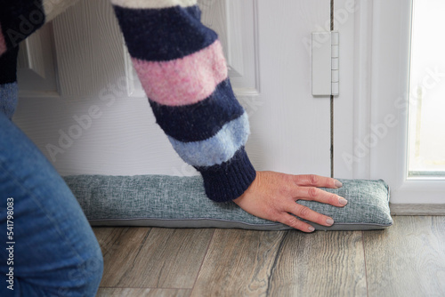 Woman Saving Enegy Insulating Home Putting Draught Excluder Tape On Window