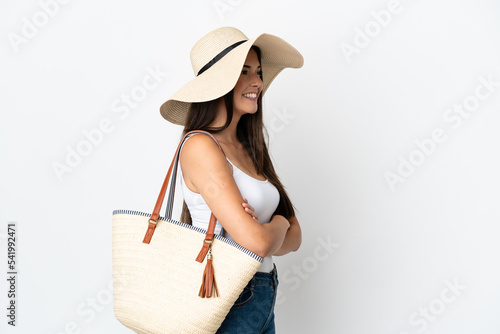 Young Brazilian woman with Pamela holding a beach bag isolated on white background in lateral position