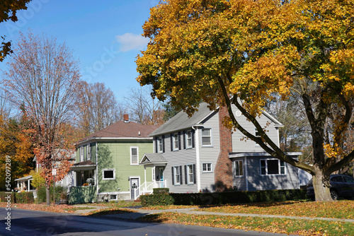 Suburban residential street with bright fall colors and middle class houses with aluminum siding