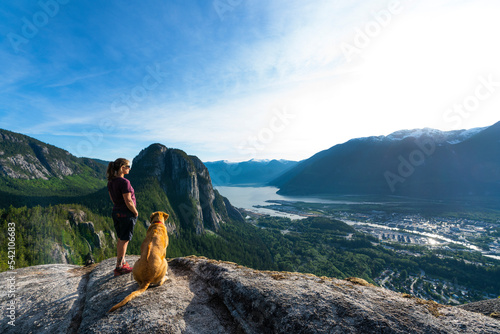 Girl and dog at viewpoint above the ocean