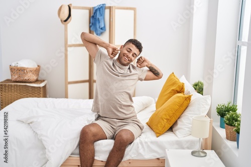 African american man waking up sitting on bed at bedroom