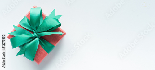 close up on red gift box with rolling ribbon on white background with copy space for merry christmas, happy new year ,festival ,birthday and anniversary, concept design