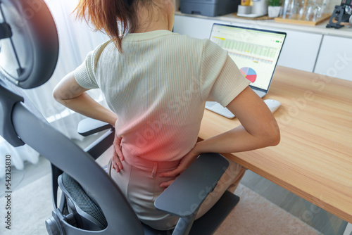 Woman having back body pain during work long time on workplace. due to Piriformis, Low Back, waist ache, lumbago, kidney, rheumatism and Spinal Compression. Office syndrome and Ergonomic concept