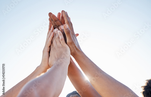 Hands, high five and collaboration on sports goal with friends in trust huddle for motivation, support and energy. Hand, fitness and people in team for exercise, workout and training against blue sky