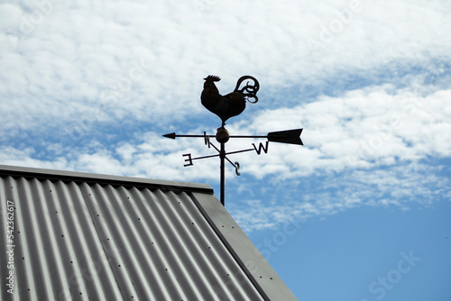 秋の青空と風見鶏のある屋根