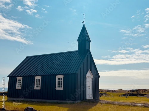 View of historical black church on south coast of Snaefellsnes peninsula under blue sky in Iceland