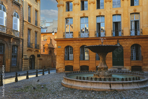 View of Provence typical city Aix en Provence with old house facade and famous old fountain in the morning