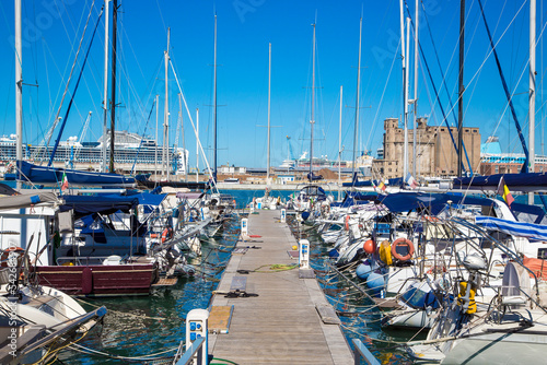 Marina bay with yachts, vessels, sailboats and other ships in Livorno, Italy. Sunny day with blue sky and sea water 