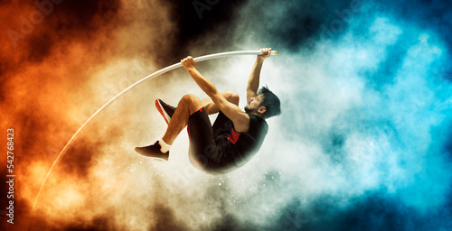 Professional pole vaulter training on smoke background