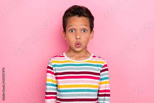 Photo portrait of astonished pupil latin small boy shocked face staring dressed trendy striped garment isolated on pink color background