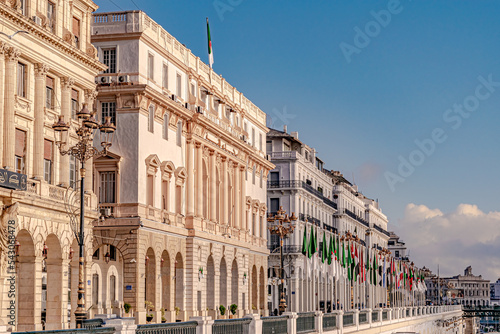 Algiers, Zighout Youcef Boulevard, Council of the Nation, Bank of Algeria and Casbah municipality white buildings with Arab league flag poles, electric street post lights and chamber of commerce