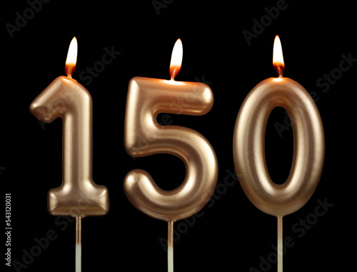 Burning golden birthday candles isolated on black background, number 150