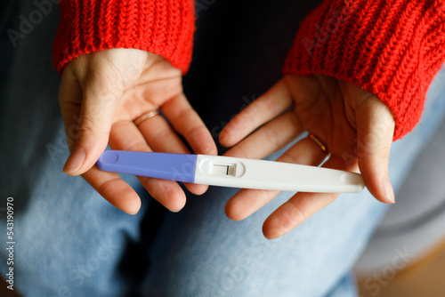 Negative pregnancy test with one strip in female hands, close-up.
