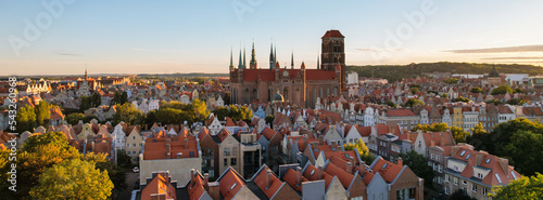 Beautiful architecture of old town in Gdansk, Poland at sunny day. Panorama banner size Aerial view from drone of the Main Town Hall and St. Mary Basilica. City Architecture from Above. Europe Tourist