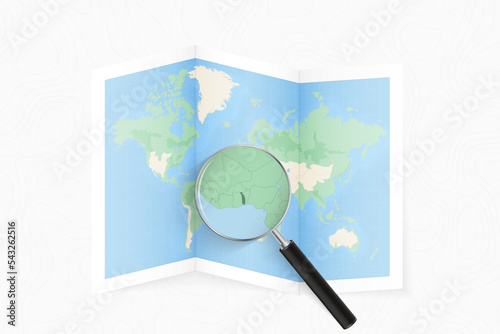 Enlarge Togo with a magnifying glass on a folded map of the world.