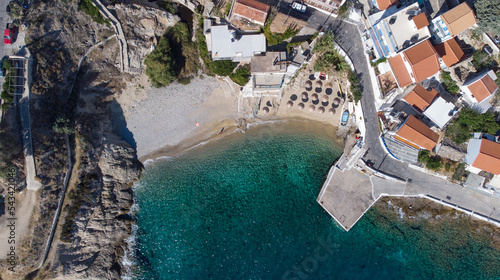Aerial view of lovely greek fisher town of Armenistis in a quiet summer morning. Port with local beach in transparent clear water at Ikaria, Greece