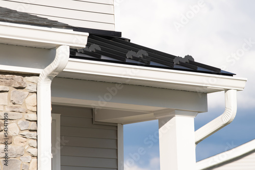 New rain gutter on a home against blue sky