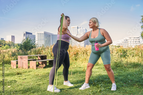 Young curvy women training with resistance bands together to lose weight