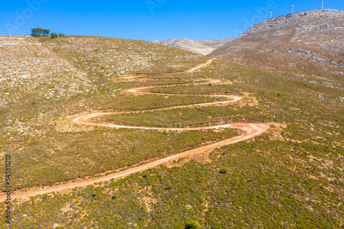Spectacular aerial view with serpentine off-road track to top of Attavyros mountain. Highest mountain in Rhodes island, Greece. Tourism and vacations concept.