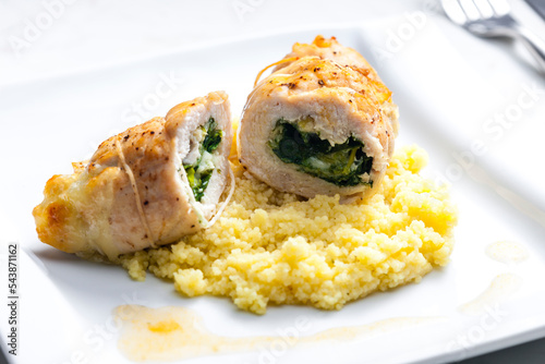 poultry roulade filled with spinach and cheese served with couscous