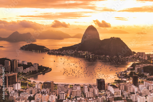 Fotografia feita do Mirante Dona Marta no nascer do sol com vista para o Pão de Açúcar e Praia de Botafogo. 