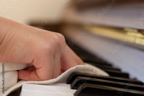 The child cleaning the piano. ピアノを掃除する子供