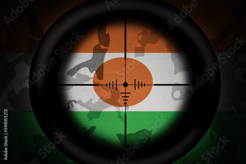 sniper scope aimed at flag of niger on the khaki texture background. military concept. 3d illustration