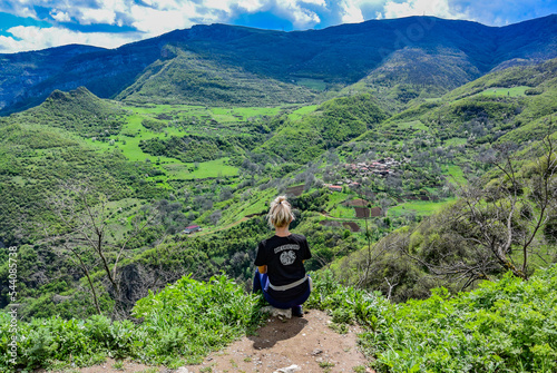 A girl on the background of a mountain view from the territory of the Tatev monastery of the 9th century, Armenia 2019