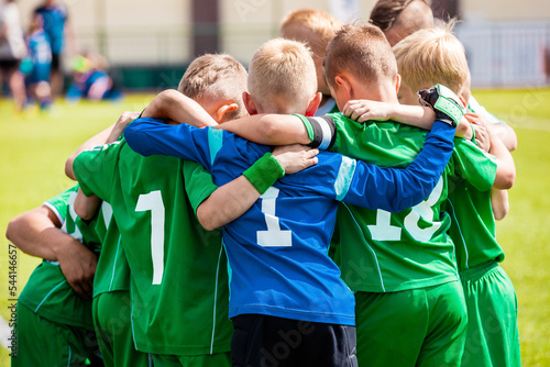 Happy boys play team sport. Kids smiling in school sports team. Children together in huddle. Cheerful children boys players of school soccer team