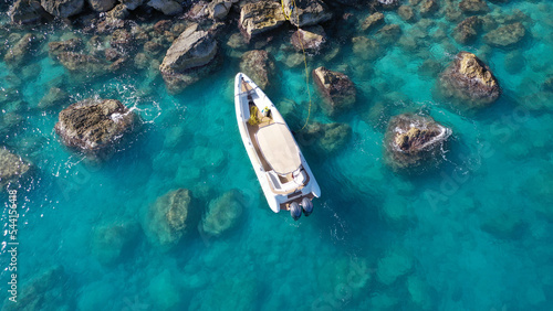 Aerial drone photo of small inflatable rib speedboat anchored in beautiful bay of small fishing coastal village of Assos in island of Kefalonia, Ionian, Greece